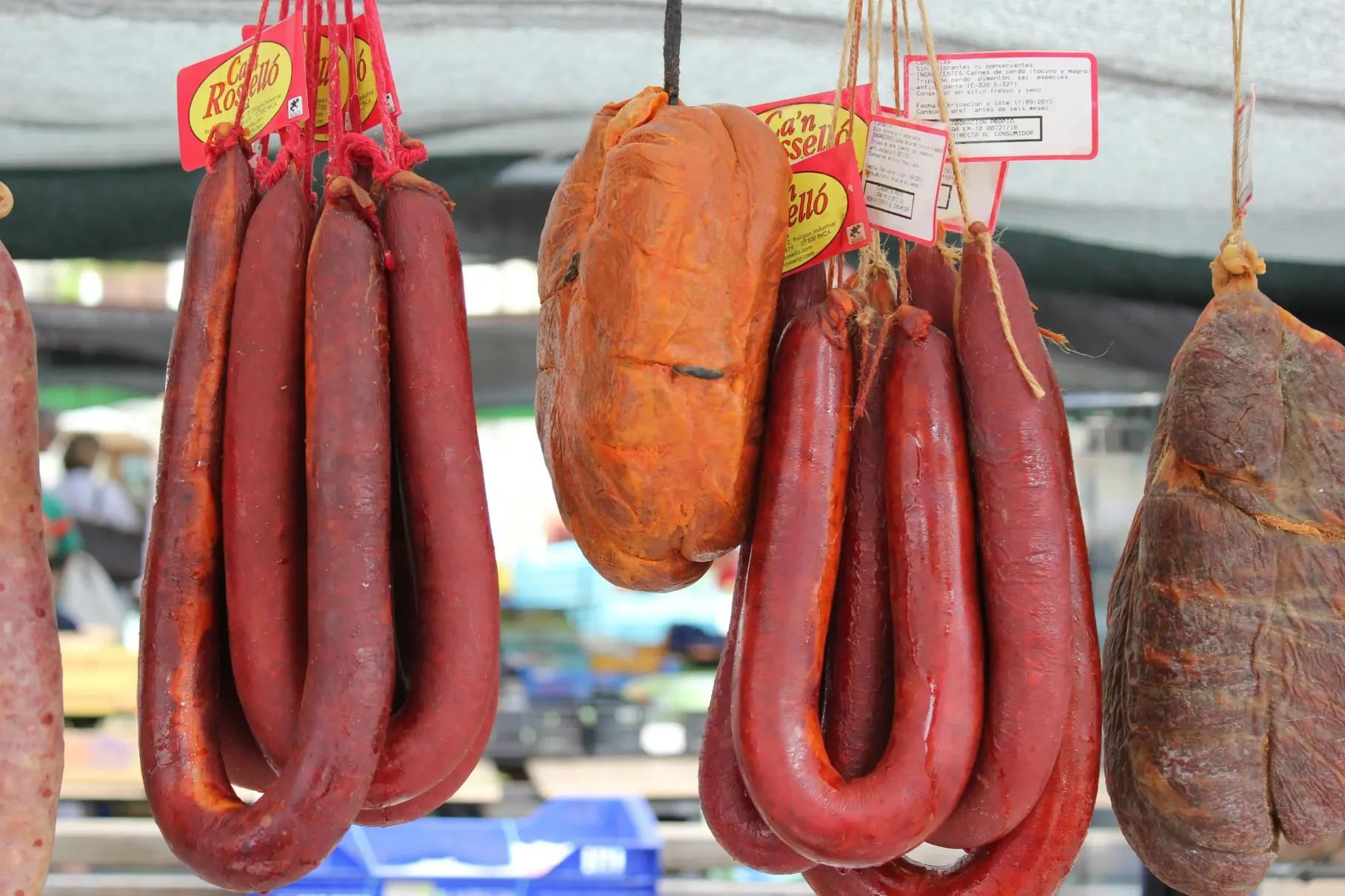Imagen de embutidos colgados en un mercado
